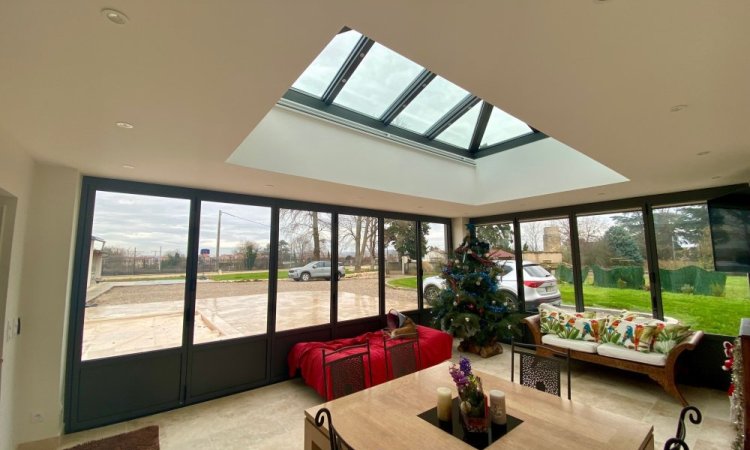 Rénovation et extension d’une habitation d’exception près de Villefranche-sur-Saône (69), intégrant des baies accordéon, une toiture vitrée et des stores sur-mesure.