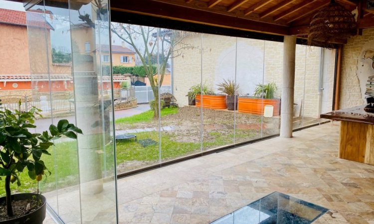 Conception et installation d’un système de fermeture de terrasse sur-mesure, harmonieusement intégré à cette habitation située dans l’Ain (01)